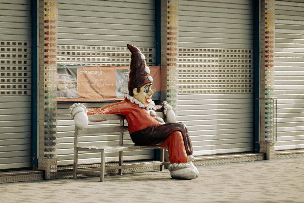 Ein Clown sitzt auf einer Bank